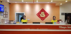 two women standing at a counter in a store at 7Days Inn Xiangfen Dingtao Hypermarket Store Branch in Linfen