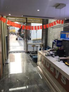 un vestíbulo de una tienda con mostrador y banderas de color naranja en 7Days Inn Enshi Railway Station Branch, en Longfengba