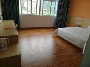 a bedroom with a bed and a large window at 7 Days Inn Wuzhishan Yanhe South Road Branch in T'ung-shih-shih