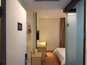 a hotel room with a bed and a desk and a tv at 7Days Inn Tongren Jiangkou Fanjing Mountain National Park Branch in Jiangkou