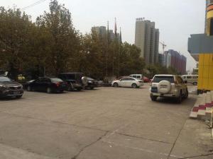 parking pełen samochodów w mieście w obiekcie 7Days Inn Luoyang Xin'an Branch w mieście Luoyang