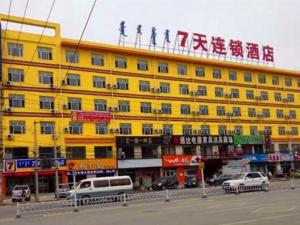 a yellow building with people on top of it at 7Days Inn Hohhot Kaitai Market Branch in Hohhot