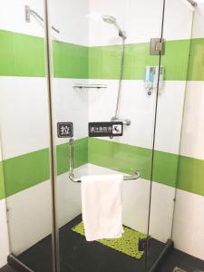 a bathroom with a shower with a white towel at 7Days Inn Hohhot Kaitai Market Branch in Hohhot