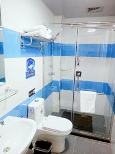7Days Inn Tianjin Binhai Bus Station North China Ceramic Shop Branch في Binhai: حمام مع دش ومرحاض ومغسلة