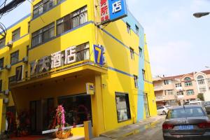 ein gelbes Gebäude mit einem Schild darauf in der Unterkunft 7 Days Hotel Taixing Wenchang Road Branch in Taizhou