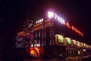 ein Gebäude mit Neonschildern in der Nacht in der Unterkunft 7Days Inn Nanchang West Station Huanan Cheng Wangcheng New District Branch in Nanchang