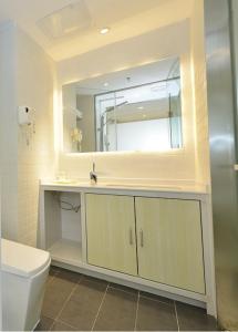 ein Badezimmer mit einem Waschbecken, einem WC und einem Spiegel in der Unterkunft 7Days Inn Nanchang West Station Huanan Cheng Wangcheng New District Branch in Nanchang