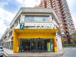 een gebouw met een geel bord erop bij 7 Days Inn Zhangjiakou Huailai Shacheng Branch in Gujiayao