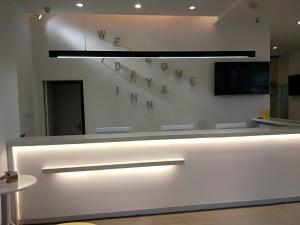 a white counter with lights on a wall at 7Days Inn Chizhou Jiuhuashan Branch in Chizhou