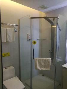 a bathroom with a glass shower with a toilet at 7Days Inn Chizhou Jiuhuashan Branch in Chizhou