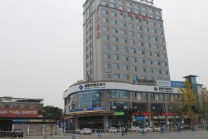 a tall building in a city with a street at 7 Days Hotel Ziyang Songtao Road Branch in Ziyang