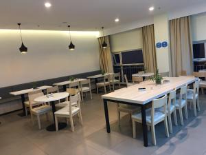 a dining room with tables and chairs and lights at 7 Days Hotel Ziyang Songtao Road Branch in Ziyang