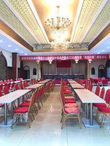 un salón de banquetes con mesas y sillas rojas en 7Days Inn Urumqi Midong Middle Road Shenhua Mining Bureau Branch, en Ürümqi