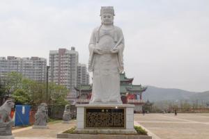 Una gran estatua de un monje en una ciudad en 7Days Inn Ganzhou Huichang Changshou Branch, 