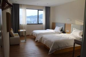 Habitación de hotel con 2 camas y ventana en 7Days Inn Ganzhou Huichang Changshou Branch, 