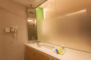 un bagno con lavandino e specchio di 7Days Inn Yunfu Jinshan Bus Intercharge Branch a Yunfu