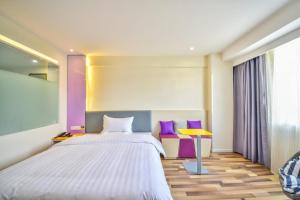 Un pat sau paturi într-o cameră la 7Days Inn Dali Erhai Park Branch