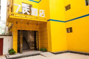 ein gelbes Gebäude mit einem Schild darüber in der Unterkunft 7 Days Hotel Panzhihua 54 Zhuanpan Center Branch in Panzhihua