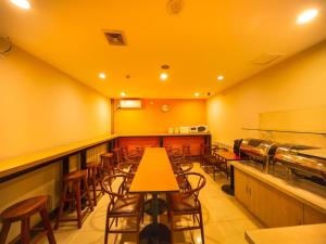 un restaurante con paredes amarillas y mesas y sillas de madera en 7Days Inn Shenyang Railway Station Taiyuan Street Branch en Shenyang