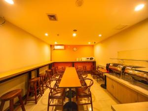 a restaurant with yellow walls and wooden tables and chairs at 7Days Inn Shenyang Railway Station Taiyuan Street Branch in Shenyang
