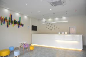 a room with a white wall with colorful art on it at 7Days Inn Xuzhou Xincheng City Council Aoti Branch in Xuzhou