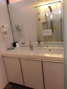 鹽城的住宿－7天酒店·盐城上冈客运站金色家园店，一间带水槽和镜子的浴室