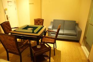 een woonkamer met een bank en een tafel en stoelen bij 7Days Inn Neijiang Longchang Xinhua Street Branch in Neijiang