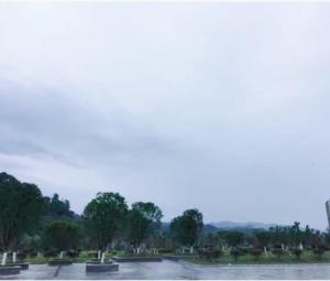 widok na park z drzewami i wodą w obiekcie 7Days Inn Rongjiang Binjiang Avenue Branch w mieście Yung-chiang
