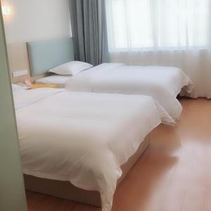Säng eller sängar i ett rum på 7Days Inn Rongjiang Binjiang Avenue Branch