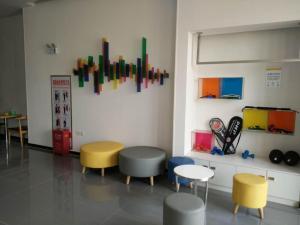 a room with chairs and tables and colorful artwork on the wall at 7Days Inn Lu'an Wanda Plaza Branch in Lu'an