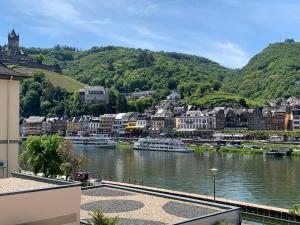 eine Stadt am Fluss mit Booten im Wasser in der Unterkunft Hotel am Hafen in Cochem