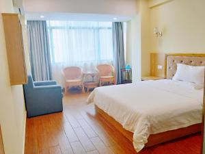a bedroom with a bed and a chair and a table at 7Days Inn Sanya Yalong Bay Branch in Sanya