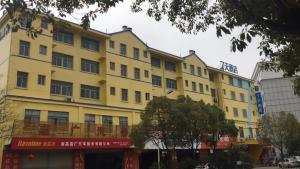 a yellow building in front of a street at 7 Days Inn Nanchang Qingshanhu Avenue Minfeng Road Branch in Nanchang