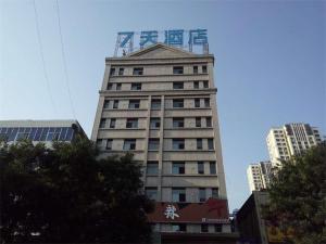 Yaopu的住宿－7天酒店·孝义人民医院店，一座高大的建筑,上面有起重机