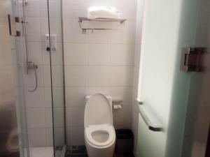 La petite salle de bains est pourvue d'une douche et de toilettes. dans l'établissement 7Days Inn Xiaoyi People's Hospital Branch, à Yaopu