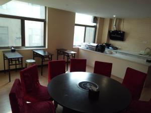 Yaopu的住宿－7天酒店·孝义人民医院店，一间带桌子和红色椅子的用餐室