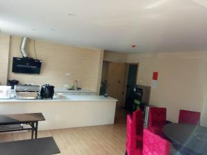 a kitchen with a counter and red chairs in a room at 7Days Inn Xiaoyi People's Hospital Branch in Yaopu