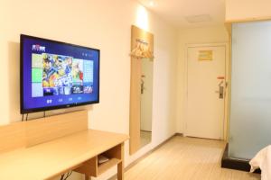 a living room with a flat screen tv on a wall at 7Days Inn Changsha Wuyi Avenue Yinbin Road Metro Station in Changsha +51 photos