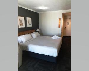 
a bedroom with a white bed and white walls at Quality Inn Airport Heritage in Brisbane
