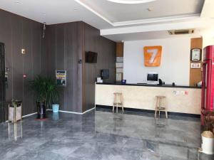 eine Lobby mit einer Theke und zwei Stühlen in der Unterkunft 7 Days Inn Haikou East Train Station North and South Fruit Market Fengxiang Road Branch in Haikou