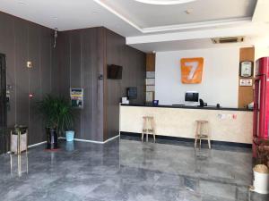 a lobby with a counter and two stools at 7 Days Inn Haikou East Train Station North and South Fruit Market Fengxiang Road Branch in Haikou