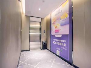 a hallway with a door to a bathroom with a sign at 7Days Inn Hengshui Hengbai International Branch in Hengshui +4 photos