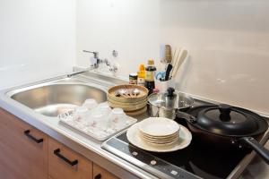 a kitchen with a sink and a stove with dishes at My Home in Tokyo in Tokyo