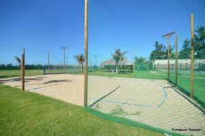 a tennis court with a net in a field at Beach Living Apartment in Aquiraz