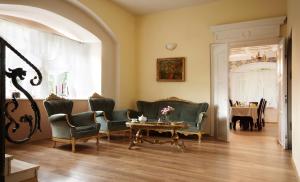 a living room with green chairs and a table at Dwór Górny in Nowa Ruda