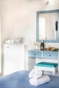 Habitación con cama con espejo y lavabo. en Aeolos Beach Resort en Mália
