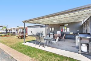 a patio with a table and chairs and a grill at Tasman Holiday Parks - Lake Mulwala in Mulwala