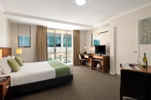 a hotel room with a bed and a desk and a television at Quest Chermside in Brisbane