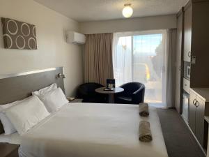 Säng eller sängar i ett rum på Adina Place Motel Apartments