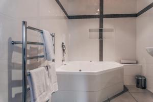 
a bathroom with a tub, sink and toilet at Barossa Valley Apartments in Tanunda
